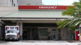 In this Aug. 24, 2021, file photo an ambulance sits outside the emergency room at The Queen's Medical Center in Honolulu. (AP Photo/Caleb Jones, File)