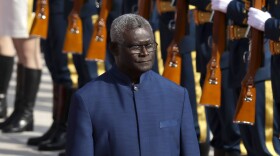 FILE - Solomon Islands Prime Minister Manasseh Sogavare reviews an honor guard during a welcome ceremony at the Great Hall of the People in Beijing, on Oct. 9, 2019.