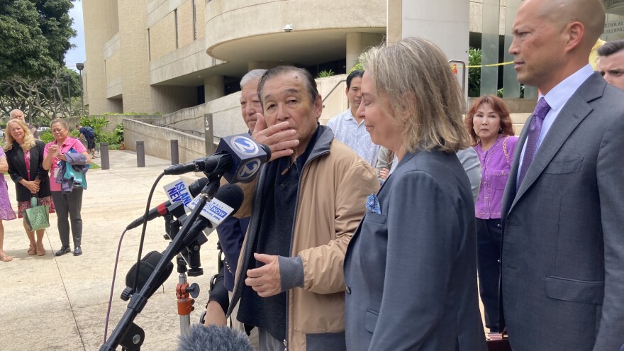 Mitsunaga & Associates CEO Dennis Kuniyuki Mitsunaga, in a beige jacket, speaks to reporters after being found not guilty in a federal bribery trial. (May 17, 2024)