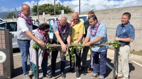 Various government officials at a dedication ceremony on Feb. 28 for the first electric vehicle charging station funded by a federal program.