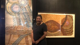 Roen Hufford stands in front of her decorative kapa piece titled "Ka Ua" (left) and her mother's kapa (right).