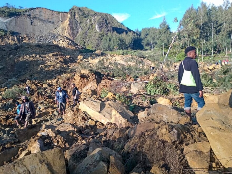 People gather at the site of a landslide in Maip Mulitaka in Papua New Guinea's Enga Province on May 24, 2024. Local officials and aid groups said a massive landslide struck a village in Papua New Guinea's highlands on May 24, with many feared dead.<br/>