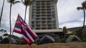 File - A resort looks over tents set up by Lahaina Strong for their "Fish-in" on Friday, Dec. 1, 2023, in Lahaina, Hawaiʻi. Lahaina Strong set up a "Fish-in" to protest living accommodations for those displaced by the Aug. 8, 2023 wildfire, the deadliest U.S. wildfire in more than a century.