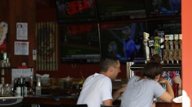 FILE - In this Aug. 24, 2021, file photo, people sit at a Waikīkī bar. (AP Photo/Caleb Jones, File)