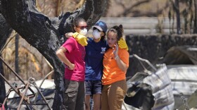 Women hug after digging through rubble of a home destroyed by a wildfire on Friday, Aug. 11, 2023, in Lāhainā, Hawaiʻi. (AP Photo/Rick Bowmer)