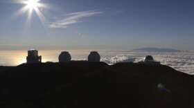 The sun sets behind telescopes at the summit of Mauna Kea, Hawaii's tallest mountain, Sunday, July 14, 2019. Hundreds of demonstrators gathered at the base of Hawaii's tallest mountain to protest the construction of a giant telescope on land that some Native Hawaiians consider sacred. State and local officials will try to close the road to the summit of Mauna Kea Monday morning to allow trucks carrying construction equipment to make their way to the top. Officials say anyone breaking the law will be prosecuted. Protestors have blocked the roadway during previous attempts to begin construction and have been arrested. (AP Photo/Caleb Jones)