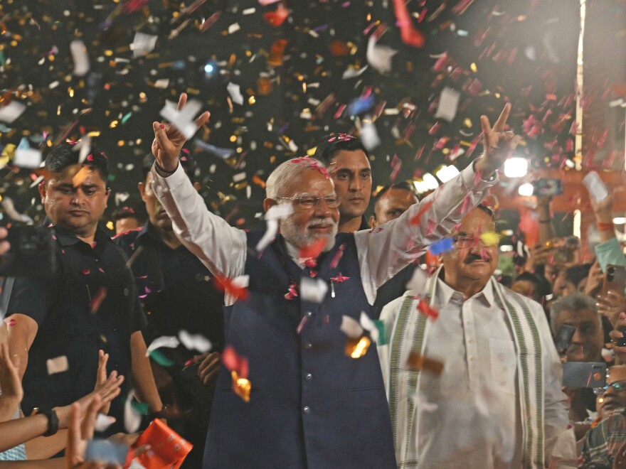 India's Prime Minister Narendra Modi flashes victory signs as he arrives at the Bharatiya Janata Party (BJP) headquarters to celebrate the party's win in the country's general election, in New Delhi, on Tuesday.