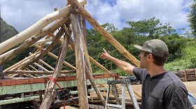 Joey Valenti of the Albizia Project points to the wood used for the last hale buildout.