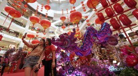 Visitors take a picture in front of lunar new year decorations inside a shopping mall in Kuala Lumpur, Malaysia Tuesday, Jan. 16, 2024. The Chinese Lunar New Year falls on Feb. 10 this year, marking the start of the Year of the Dragon, according to the Chinese zodiac.