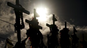 FILE - Lei adorn crosses at a memorial for victims of the August wildfire above the Lahaina Bypass highway, Wednesday, Dec. 6, 2023.