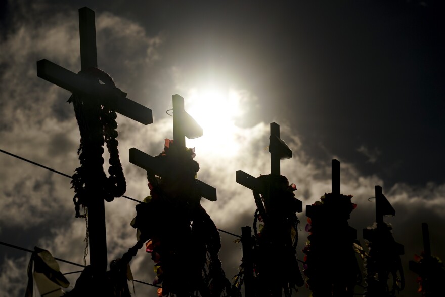 FILE - Lei adorn crosses at a memorial for victims of the August wildfire above the Lahaina Bypass highway, Wednesday, Dec. 6, 2023.