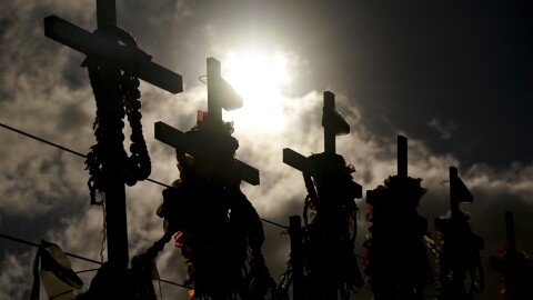 FILE - Lei adorn crosses at a memorial for victims of the August wildfire above the Lahaina Bypass highway, Wednesday, Dec. 6, 2023.