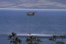 FILE - A Hawaiʻi National Guard Chinook helicopter scoops up water from the ocean near Lahaina, Hawaiʻi, Wednesday, Aug. 16, 2023.