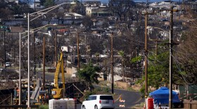 A vehicle drives by a checkpoint in front of the burn zone, Friday, Dec. 8, 2023, in Lahaina, Hawaiʻi. Recovery efforts continue after the August wildfire that swept through the Lahaina community on Hawaiian island of Maui, the deadliest U.S. wildfire in more than a century.