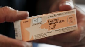 FILE - Akron fire medic Paul Drouhard shows a box containing naloxone hydrochloride, a drug carried in all their department emergency response vehicles to treat opioid overdose patients.