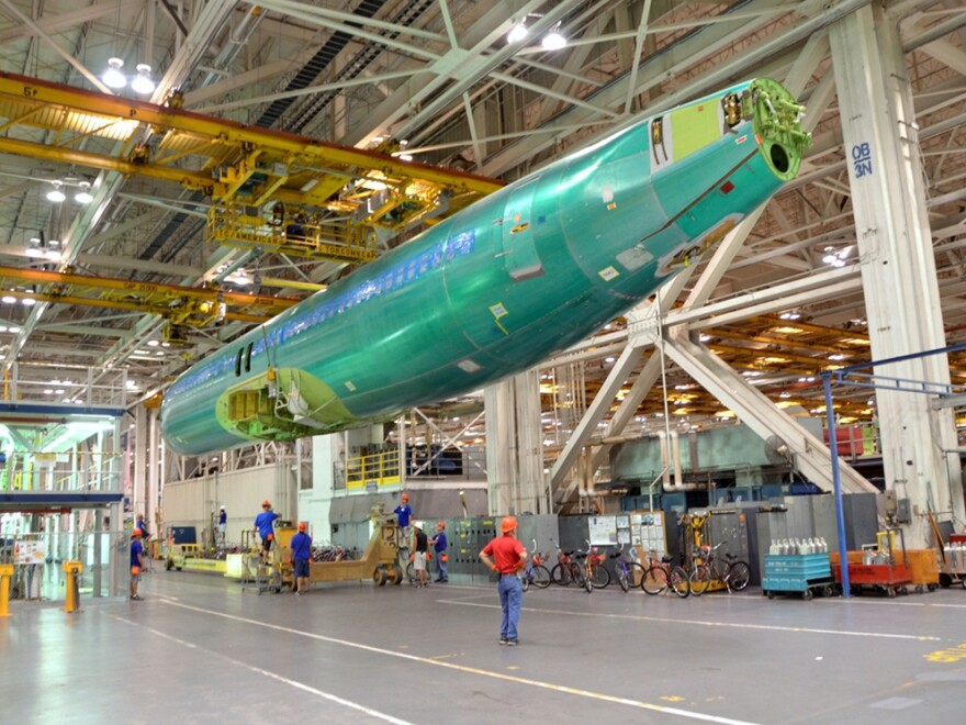 An unfinished 737 fuselage is suspended from the ceiling at Spirit's Wichita factory.