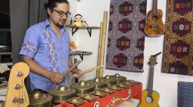 Ronald Querian is playing the kulintang at his home studio.