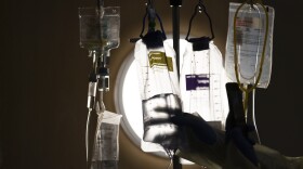 FILE - A nurse checks on IV fluids while talking to a COVID-19 patient in Los Angeles, Dec. 13, 2021. (AP Photo/Jae C. Hong, File)