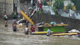 Workers transfer construction materials to higher grounds along a swollen river due to enhanced rains brought about by Typhoon Doksuri on Thursday, July 27, 2023, in Marikina city, Philippines. Typhoon Doksuri lashed northern Philippine provinces with ferocious wind and rain Wednesday, leaving several people dead and displacing thousands of others as it blew roofs off houses, flooded low-lying villages and triggered dozens of landslides, officials said.