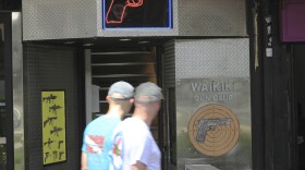 FILE - People walk past the Waikiki Gun Club, Thursday, June 23, 2022, in Honolulu. (Marco Garcia/AP)