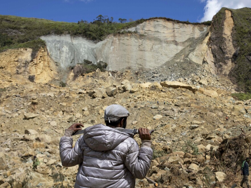 A villager looks up at the top of a mountain that sheared away and caused a landslide in Papua New Guinea, on Monday, May 27, 2024. Debris from the landslide covered Yambali village in the Highlands of the country with a blanket of rubble that is about 650 feet deep, authorities said.