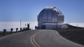 Visitors take photos near an observatory on the summit of Maunakea in Hawaiʻi, on Saturday, July 15, 2023. Over the last 50 years, astronomers have mounted 13 giant telescopes on Maunakea's summit.