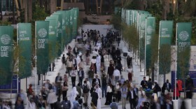 People walk through the COP28 U.N. Climate Summit, Monday, Dec. 4, 2023, in Dubai, United Arab Emirates. (AP Photo/Peter Dejong)