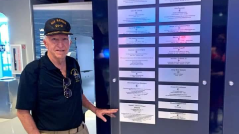 Retired Navy Chaplain Steven Jensen displays his plaque of honor at the Intrepid Museum's Honor Wall in New York City.