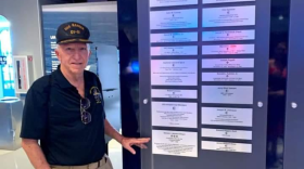 Retired Navy Chaplain Steven Jensen displays his plaque of honor at the Intrepid Museum's Honor Wall in New York City.