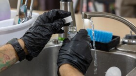 FILE - A Navy contractor collects a water sample from a kitchen sink in a residence on Joint Base Pearl Harbor-Hickam, Hawaiʻi. (U.S. Navy photo by Mass Communication Specialist Seaman Krystal Diaz)