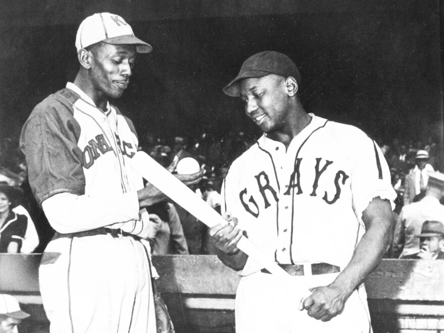 Satchel Paige of the Monarchs talks with Josh Gibson of the Homestead Grays before a game in Kansas City in 1941.