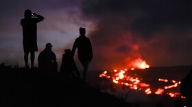 People watch lava from the Maunaloa volcano Thursday, Dec. 1, 2022, near Hilo, Hawaiʻi. (AP Photo/Gregory Bull)