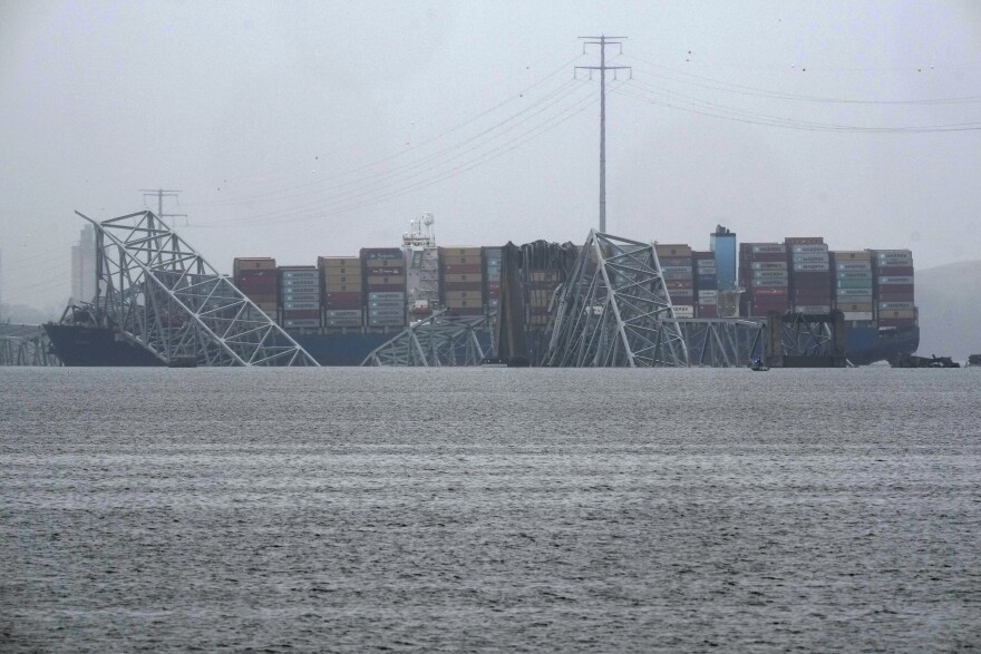 A container ship rests against the wreckage of the Francis Scott Key Bridge on Thursday, March 28, 2024, in Baltimore, Md. After days of searching through murky water for the workers missing after the bridge collapsed, officials are turning their attention Thursday to what promises to be a massive salvage operation. (AP Photo/Matt Rourke)