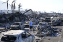 FILE - A man walks through wildfire wreckage Aug. 11, 2023, in Lāhainā, Hawaiʻi. Maui authorities said Thursday, Sept. 14, that they are planning to start letting residents and business owners make escorted visits to their properties in the restricted Lahaina Wildfire Disaster area later this month. (AP Photo/Rick Bowmer, File)