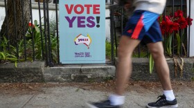 FILE - A pedestrian walks past a vote Yes poster for the Voice referendum in Sydney, Australia, Monday, Sept. 11, 2023. Australia’s Prime Minister Anthony Albanese said Tuesday, Sept. 26, that opinion polls suggest Indigenous Australians overwhelmingly support a proposal to create their own representative body to advise Parliament and have it enshrined in the constitution. (AP Photo/Mark Baker, File)