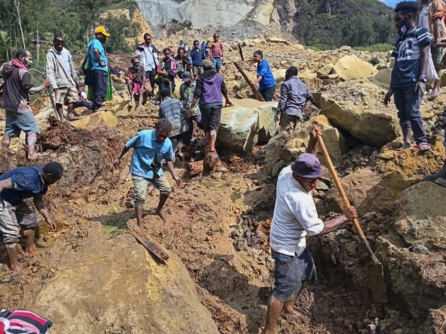 Villagers search through a landslide in Yambali, in the Highlands of Papua New Guinea, on Sunday, May 26, 2024. The International Organization for Migration feared Sunday the death toll from a massive landslide is much worse than what authorities initially estimated.