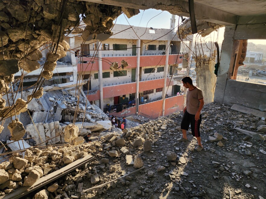  A man looks over the ledge at a bombed-out school in Khan Younis on May 24.