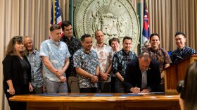 Local officials watch Gov. Josh Green sign a handful of housing reform bills that passed through the state Legislature. (May 28, 2024)